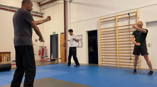 Personen in einem Trainingsraum, die Wing Chun Techniken üben.